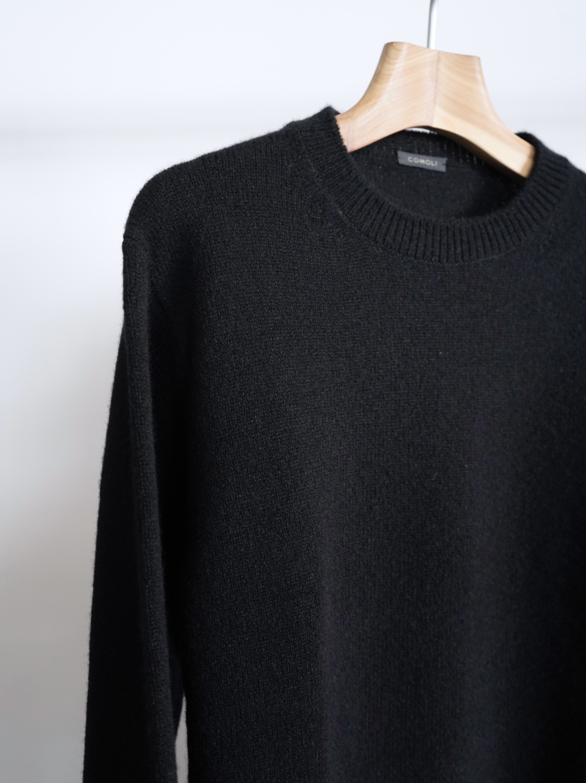 COMOLI」ラムズウールクルーネックニット