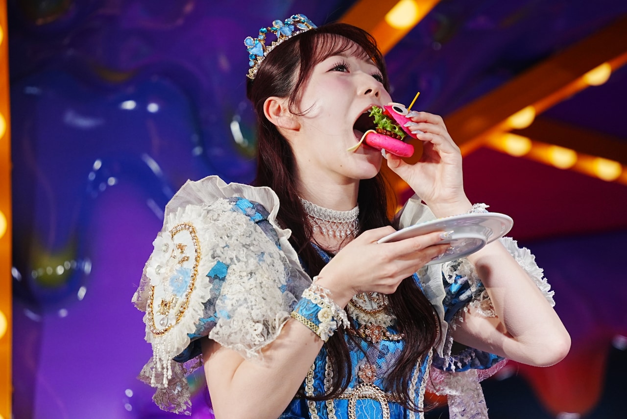 ミニハンバーガーにかぶりつく真中まな（FRUITS ZIPPER）。 [画像